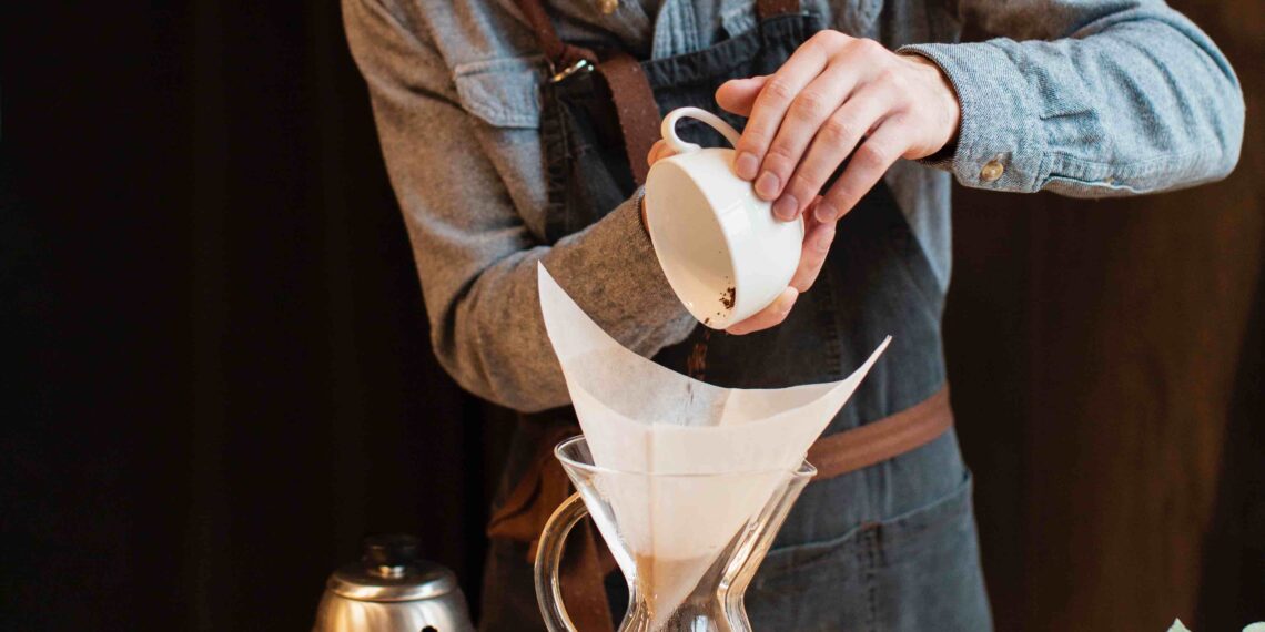 Homem preparando um café coado.