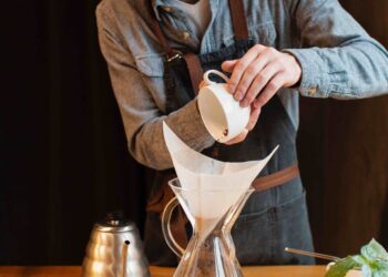 Homem preparando um café coado.